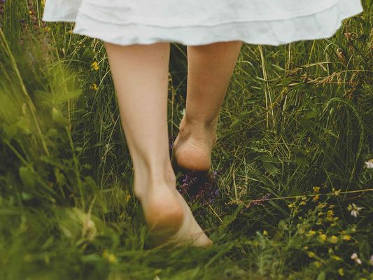 Barfuß laufende Füße im Gras